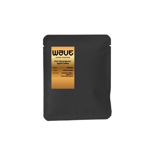 A matte black drip coffee of Wave Coffee Roasters Port Wine Barrel Aged Coffee, featuring a gold label on the front, set against a plain white background. super rare and uniq coffee