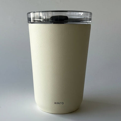 Beige tumbler with a clear lid on a light gray background