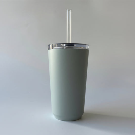 Gray tumbler with a straw and brown label on a light gray background