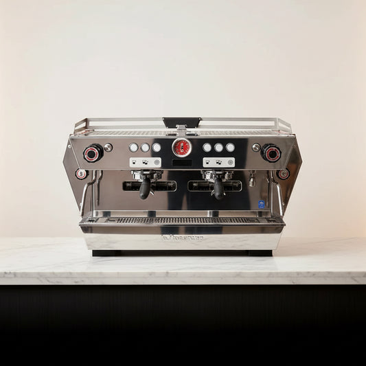 A professional espresso machine with a stainless steel body and a distinctive red geometric side panel, shown on a plain white background. La Marzocco KB90