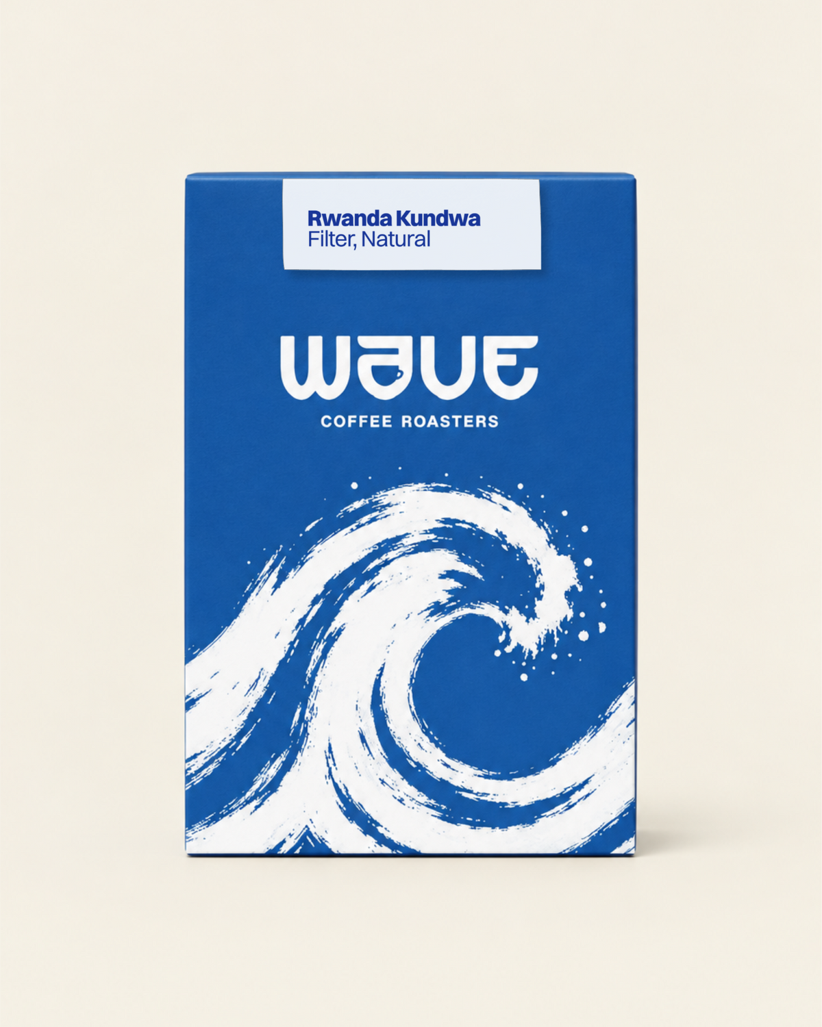 A rectangular coffee roaster box standing upright on a light beige background. The box has a blue or a dark blue design with a large white wave illustration and the visible brand name 'wave coffee roasters' with specialty coffee label: 'Rwanda Kundwa Filter, Natural'
