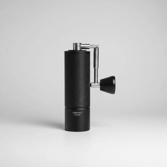Black manual coffee grinder with silver handle on a white background